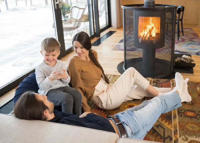 Family sitting by the roaring fire in the fireplace