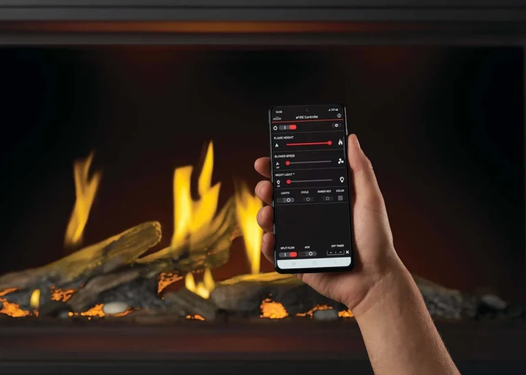 A person holding a phone with Napoleon eFire, a smart fireplace feature, in front of a burning fireplace.