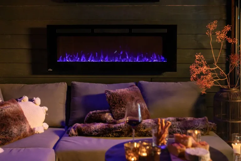 A cozy living room scene with a modern electric fireplace mounted on a dark wood wall, displaying vibrant blue flames.